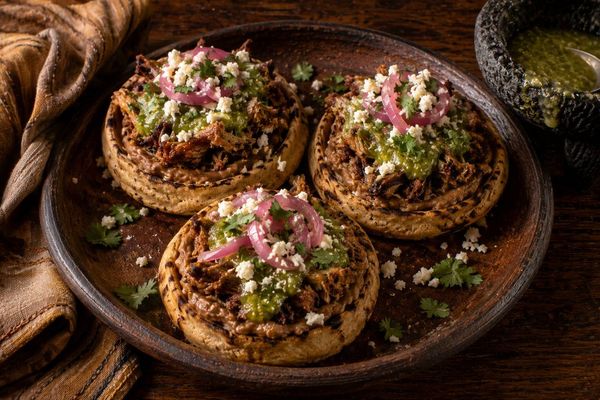 Carnitas Sopes - Refried Beans · Avocado Salsa Molcajete · Cotija